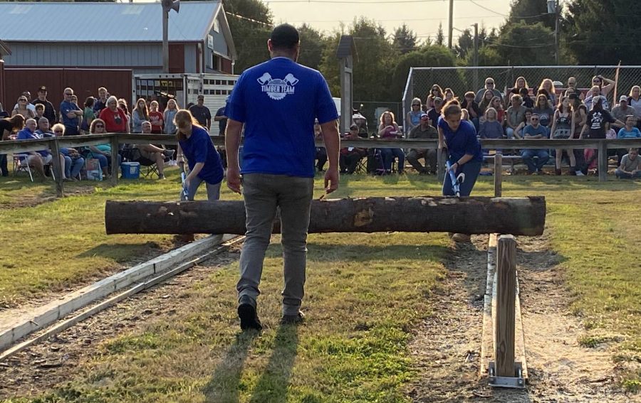 Abigail Risi and Jill Fitzgerald from the Woodbury FFA Timber Team compete in the log roll event, under instruction of Andrew Zielinski, who has his back to the camera.  It is crucial to keep the log from falling off the rails to be successful in this competition.