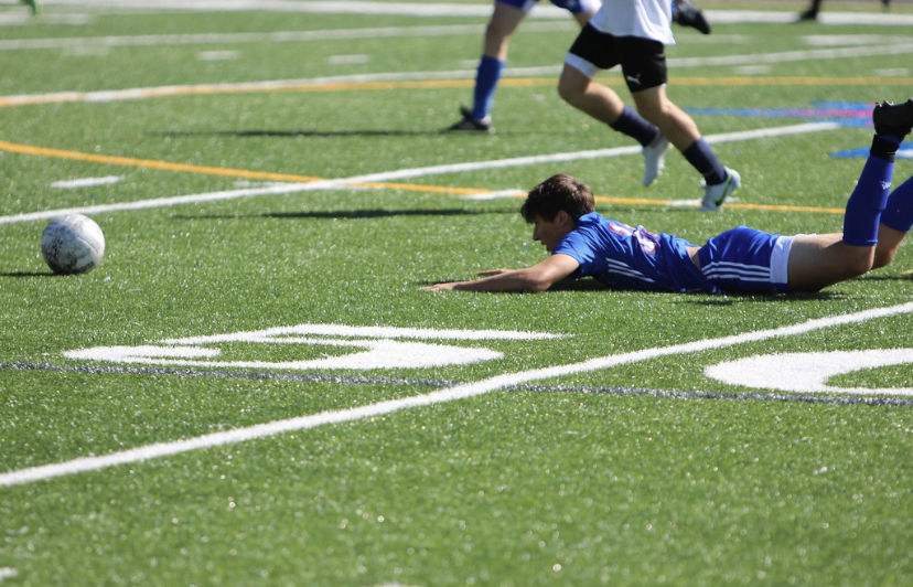 Boys soccer player Zack Hellwinkle on the ground after a foul during the game. 