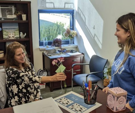 Bianca Gracia, senior floriculture student, hands flowers to Nonnewaug secretary Lisa Gombos for the Petal It Forward event. This nationwide tradition occurs on Oct. 19 to spread positivity to others.