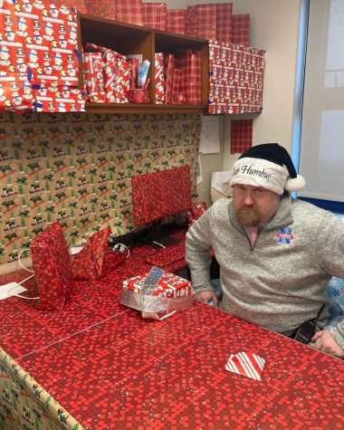 Nonnewaug athletic director Declan Curtin sits in his office, which was completely wrapped in paper at the start of the final week before holiday break.