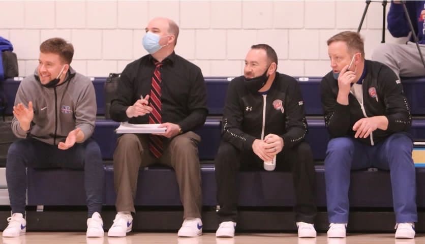 Nonnewaug assistant boys basketball coach Kyle Fitzpatrick, left, sits on the bench during a game last season. Fitzpatrick is a former UConn walk-on.