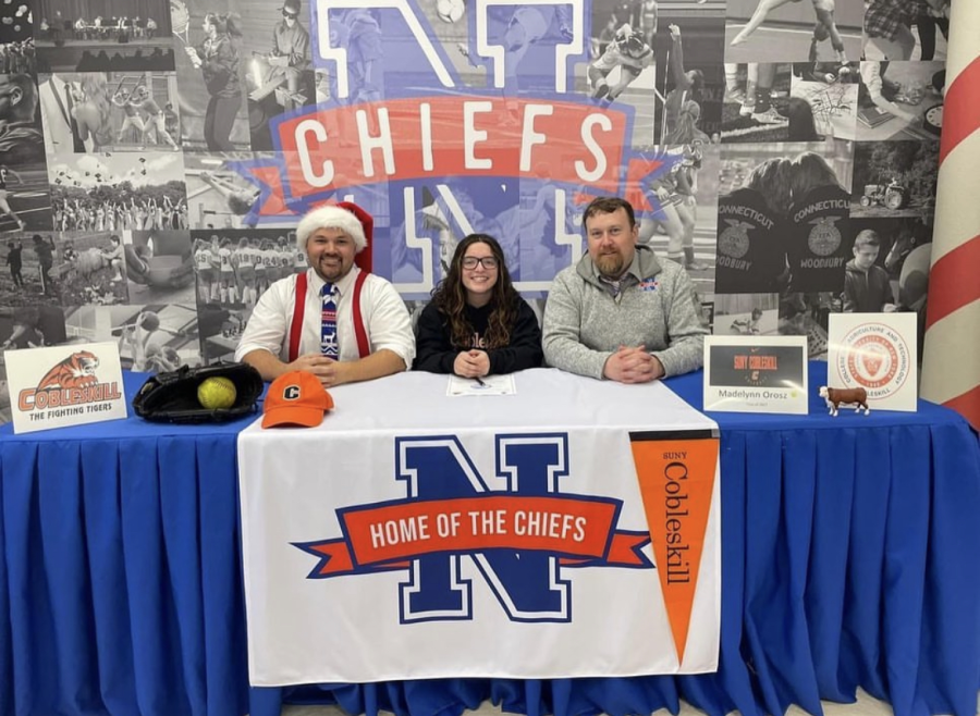 Maddie+Orosz%2C+center%2C+poses+for+a+photo+next+to+social+studies+teacher+Kyle+Brannan%2C+left%2C+and+athletic+director+Declan+Curtin+as+she+signs+to+play+softball+for+SUNY+Cobleskill+next+season.+