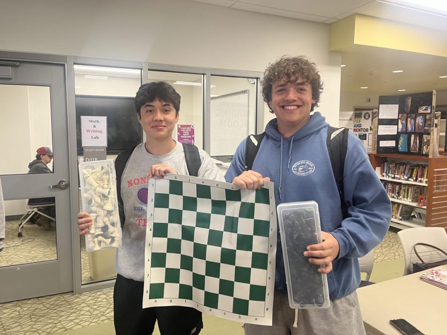 Senior Ben Shea, left, and junior Luke Cenatiempo pose with a chess board in Nonnewaugs LMC.
