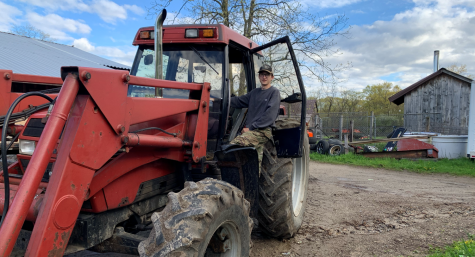 TJ Butkus with his familys most used tractor at Laurel Knoll Farm, a farm thats been in the Butkus family for generations. 