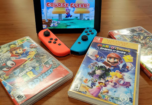 A Nintendo Switch system shows “Super Mario 3D World” with assorted recent Mario video games surrounding it, including Super Mario Odyssey and Mario + Rabbids: Sparks of Hope.