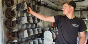 Evan Butkievich looks through the stock of horseshoes in his boss work trailer. He is an avid horse farrier, following through with his SAE requirements.