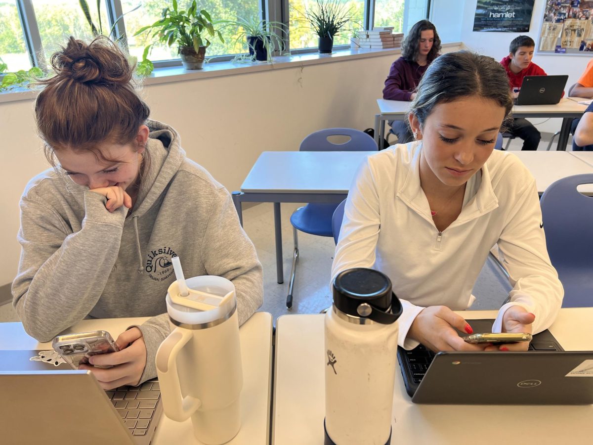 Nonnewaug+seniors+Kaylee+Jackson%2C+left%2C+and+Juliette+Nichols+use+their+phones+in+class.+The+schools+new+cellphone+policy+is+a+way+to+limit+distractions+in+the+classroom.