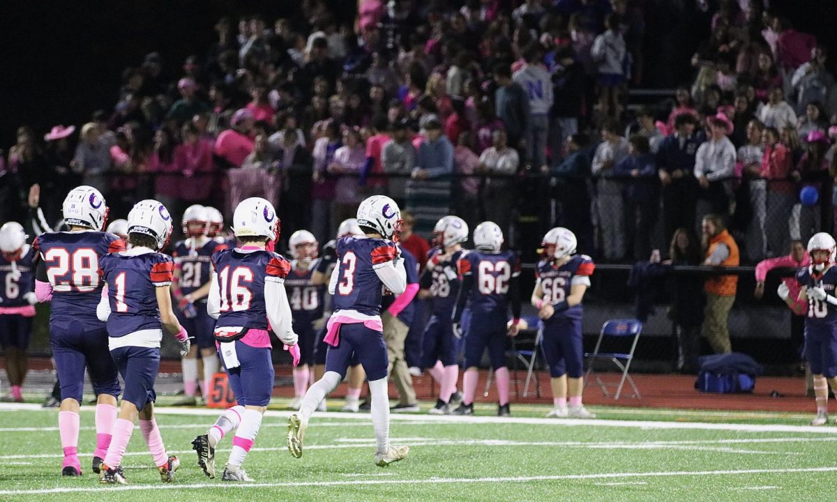 The Northwest United football team, wearing pink accessories, walks off the field during its win over Prince Tech-Innovation on Oct. 19. They were supported by a pink-clad student section.