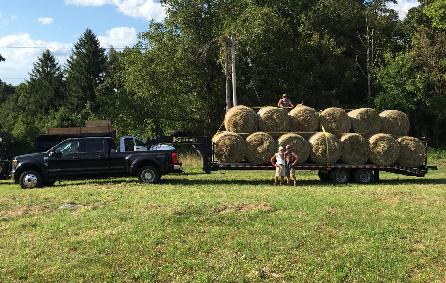 Mykal Kuslis poses on his family farm with a trailer load of hay bales. The farm, which has been in his family for nearly a century, sells hay to local farmers. (Courtesy of Mykal Kuslis)