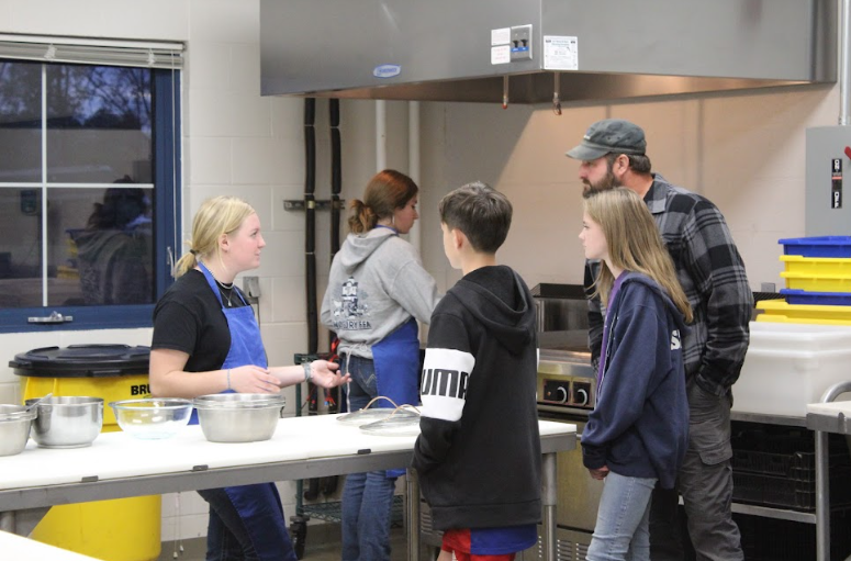 Junior Haley Sarandrea, left, speaks to eighth-graders and their parents about the opportunities in Nonnewaug’s agricultural production class. Sarandrea taught visitors how to craft mozzarella cheese out of goat's milk. (Courtesy of the Woodbury FFA/Instagram)