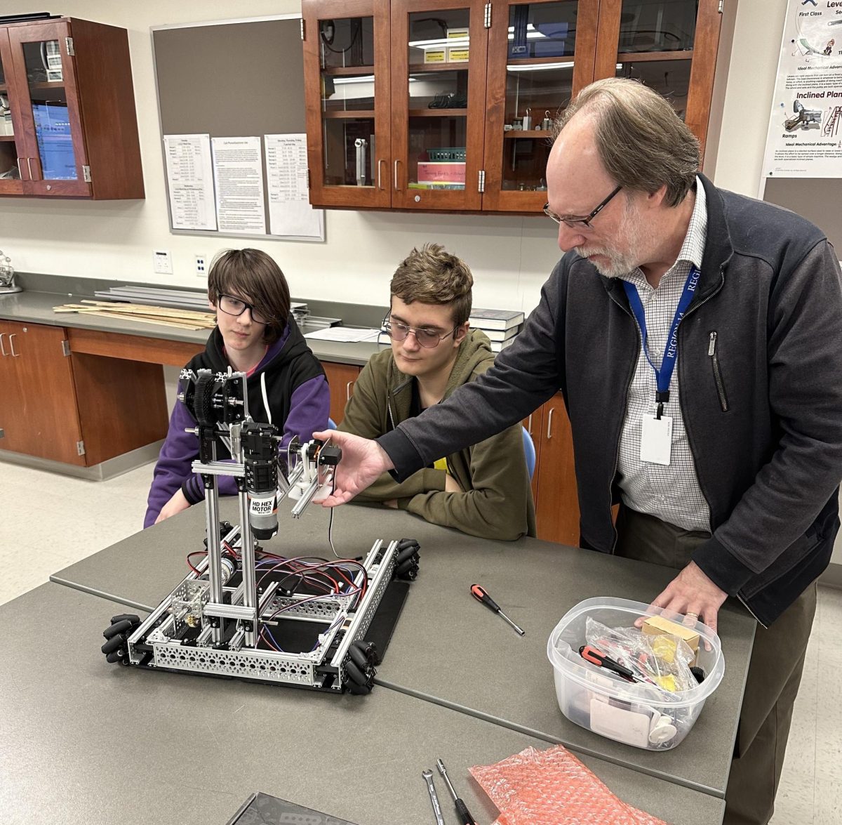 William+Pease%2C+Nonnewaug+science+faculty+and+club+advisor+for+robotics%2C+attaches+crucial+pieces+onto+this+robot+with+freshmen+Collin+Palaia%2C+left%2C+and+Jack+Braddock.