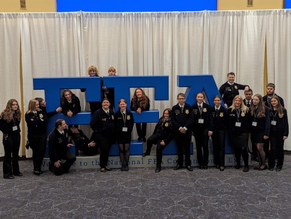 Woodbury FFA students gather around an FFA symbol in the lobby of the Indianapolis Convention Center during the National FFA Convention.