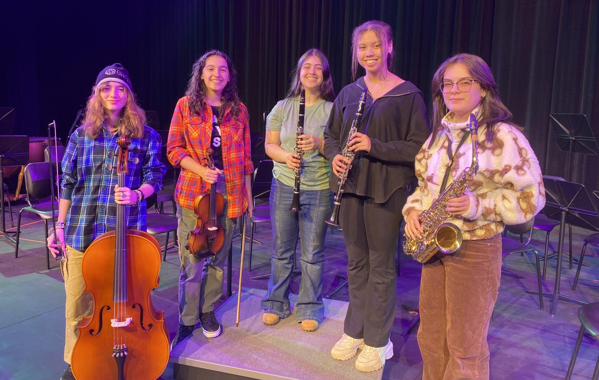 NHS Orchestra students, from left, Ellie Mansfield, Almi Morales, Gianna Ruby-DaSilva, Victoria DaSilva, and Kaia Zupnick pose on Nonnewaug’s auditorium stage. They will perform at the fall concert Nov. 18.