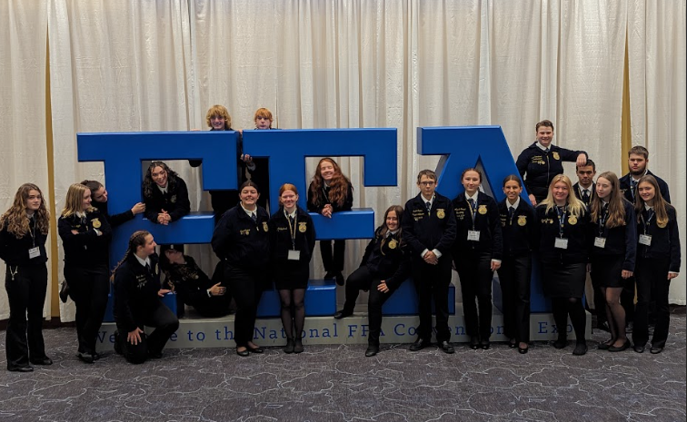 The Woodbury FFA chapter poses for a picture around the FFA Nationals sign in the convention center in Indianapolis.
