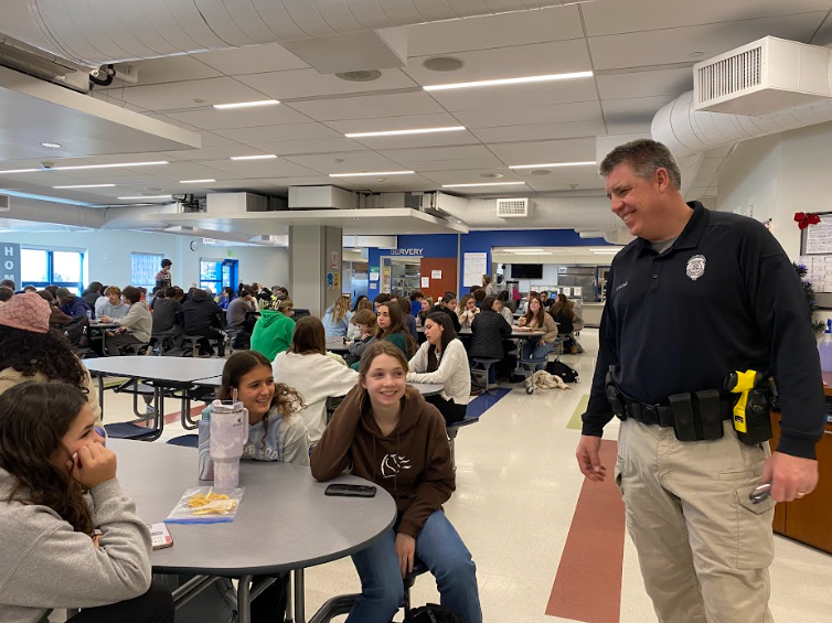 Officer Chris O’Toole, right, patrols the cafeteria and catches up with students.  Nonnewaug has been OTooles home for several years following a career as an officer in Southbury.