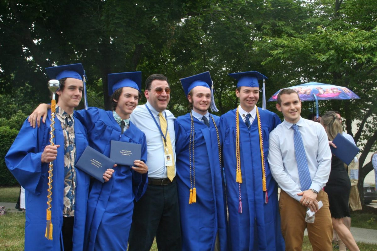 Teachers John Dominello and Conor Gereg pose for a photo with Nonnewaug Graduates. Throughout Dominello’s 15 years of teaching, students have noted the lifelong relationships he builds with students. 