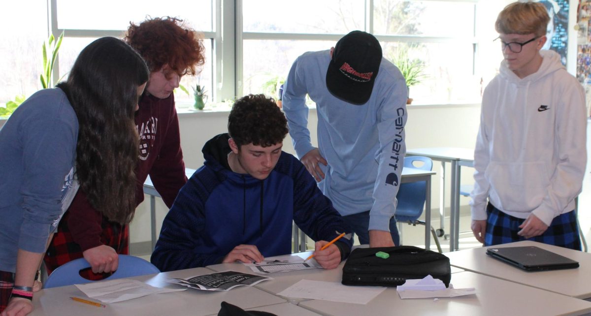 A freshman advisory works to solve a clue during the red-out scavenger hunt Feb. 9 at Nonnewaug.