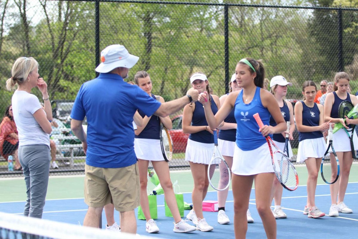 Skylar Chung fist bumps head coach Chris York during before a spring match last season. Chung will serve as the teams captain this season, playing as one of the top singles players. 