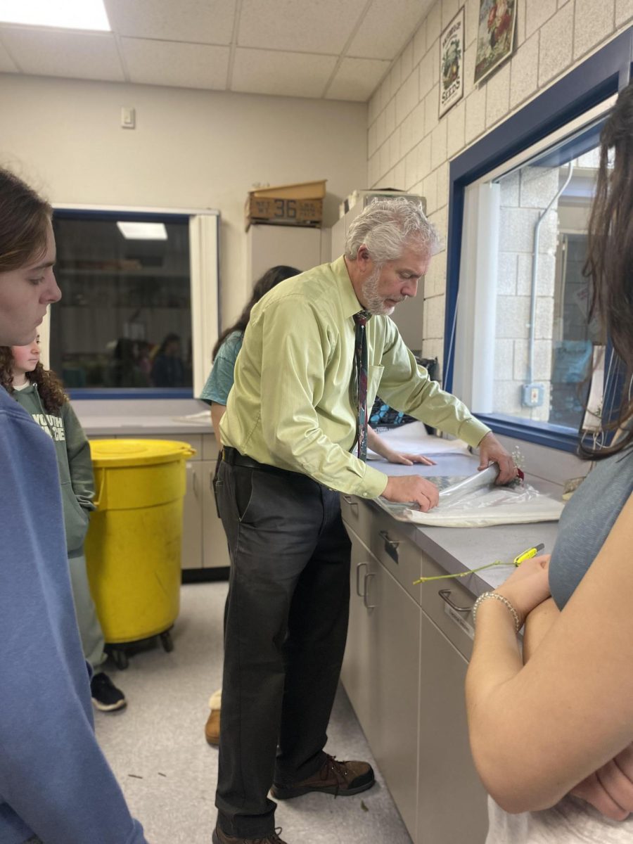 NHS Floriculture instructor Eric Birkenberger, instructs students on how to wrap order to fit customer orders. 