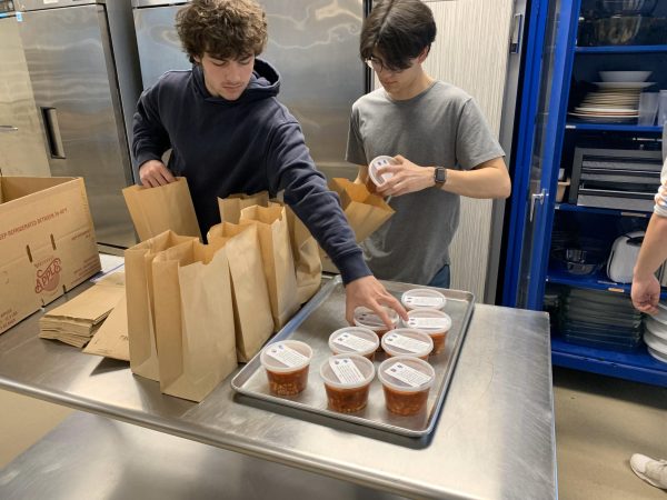 NHS Advanced Culinary students Eddie Longo (left) and Elijah Llanos (right) package up minestrone soup for community senior citizens. The soup was created in collaboration with Woodbury Middle School culinary students. 