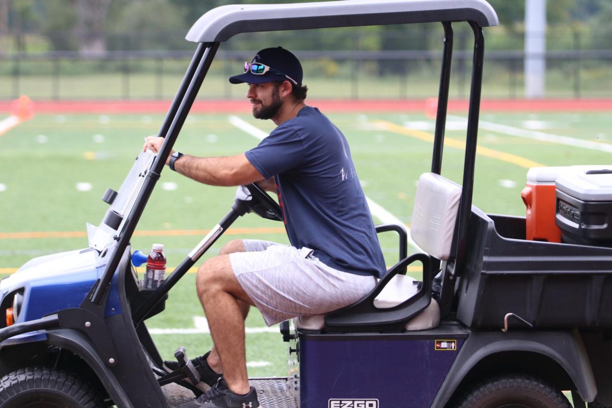 Nonnewaug+athletic+trainer+Sean+McGee+drives+his+golf+cart+prior+to+a+football+game+last+season.+McGee+will+be+on+campus+throughout+the+summer+as+athletes+engage+in+conditioning+and+practices.+%28Courtesy+of+Noreen+Chung%29