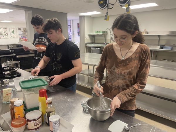 (Right) junior Haylee Molina, senior Andrew Parrella, and junior Cace Hackett prepare a icing for the berry turnover the dessert course the advance culinary student are giving the senior citizens for Thursday, April 4ths meal. 