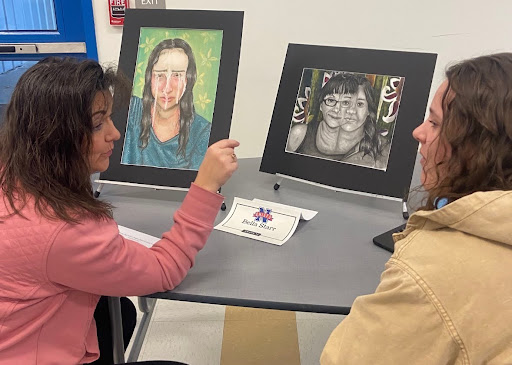 Art teacher Leeza Desjardins, left, discusses an MBLE project with senior Bella Starr. In the first week of January, students attended an MBLE showcase to present their projects they worked hard on. (Courtesy of Nonnewaug High School/Instagram)