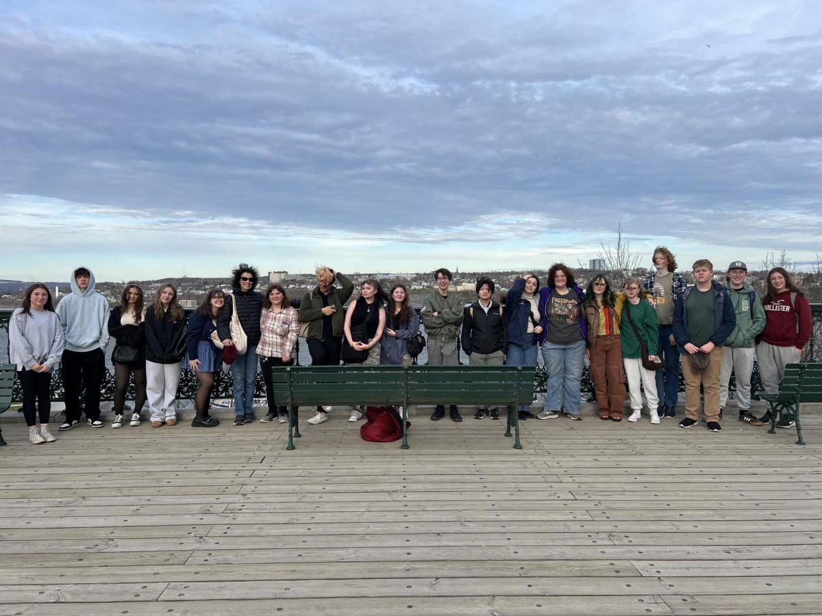 Nonnewaug French teacher Kate Peterson stands with her students in front of the St. Lawrence river during their Quebec City field trip.