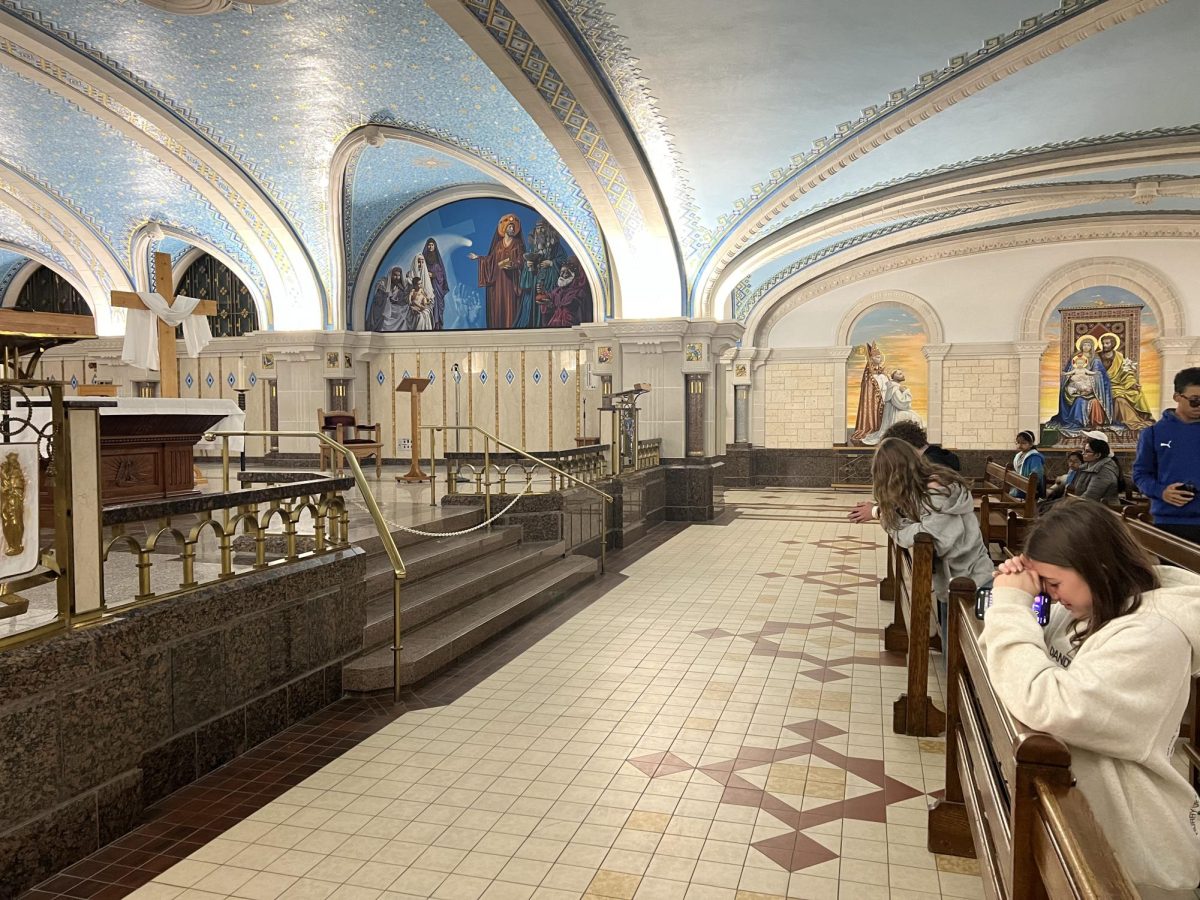Nonnewaug sophomores Anna Crocker, Emily Thomas, and Billy Herr pray in the below-ground level of the basilica church Sainte-Anne-de-Beaupré.