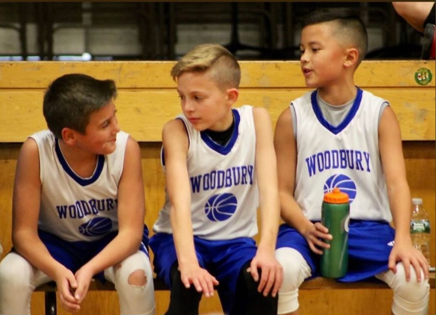 From left, Brady Herman, Robert Metcalfe, and Derek Chung talk on the bench during a Woodbury youth basketball game. The three, who are Nonnewaug sophomores, formed their friendship over sports. (Courtesy of Noreen Chung)