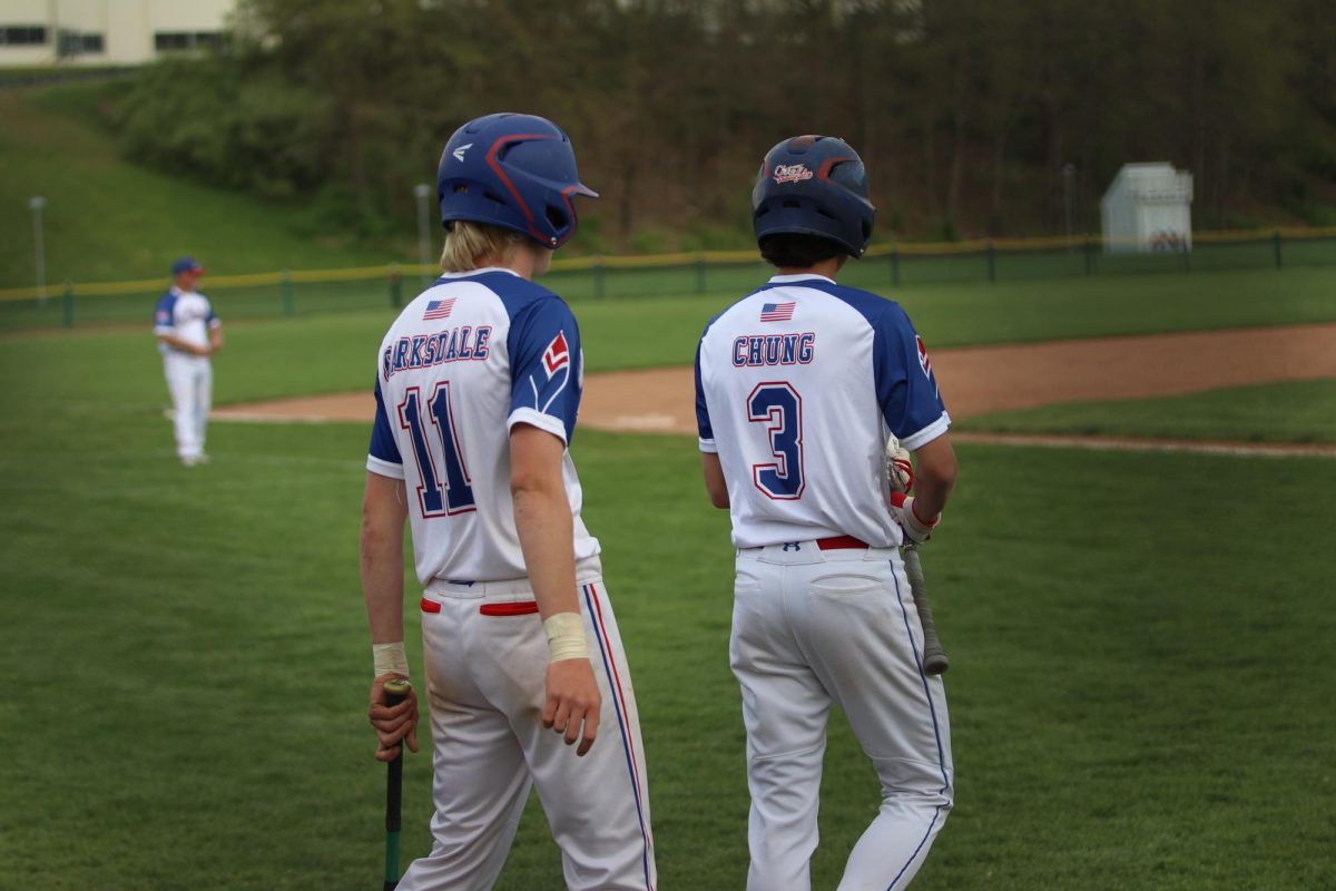 Junior R.J. Barksdale, left, and sophomore Derek Chung prepare between innings to bat against Shepaug on May 3. Barksdale is one of just two returning starters from last years state championship team, and Chung is one of the many sophomores who have contributed to this years team. (Courtesy of Noreen Chung)