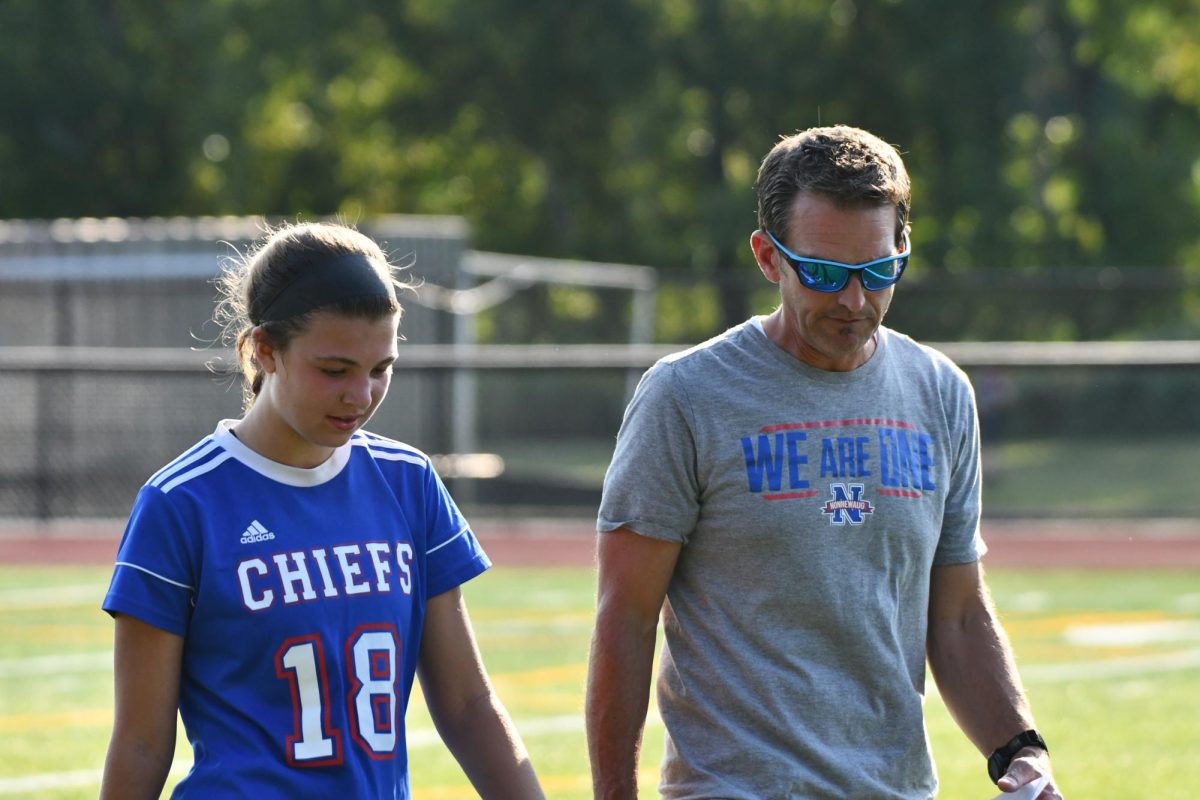 Nonnewaug girls soccer coach Adam Brutting, right, talks to junior Ella Quinn during a game earlier this season.