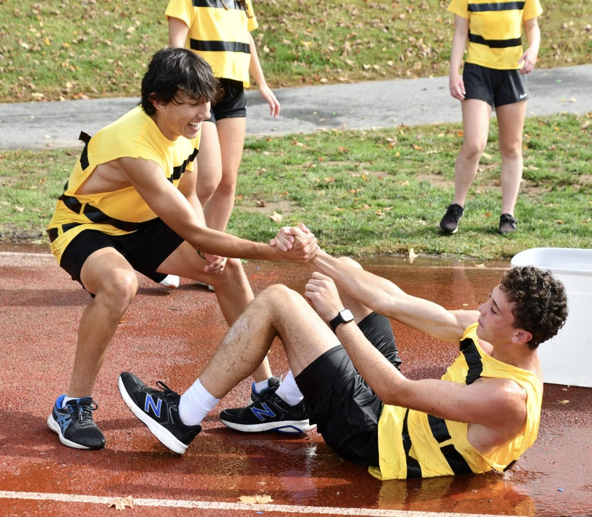 Liam Sandor, left, helps up Lincoln Nichols at the water balloon event during the Class of 2025 Senior Field Day on Sept. 27.