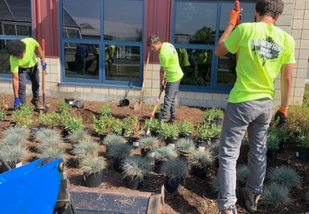 Landscaping students actively work during class around the agriculture building. Students in their new uniforms work together as a team. (Courtesy of Jennifer Plasky)
