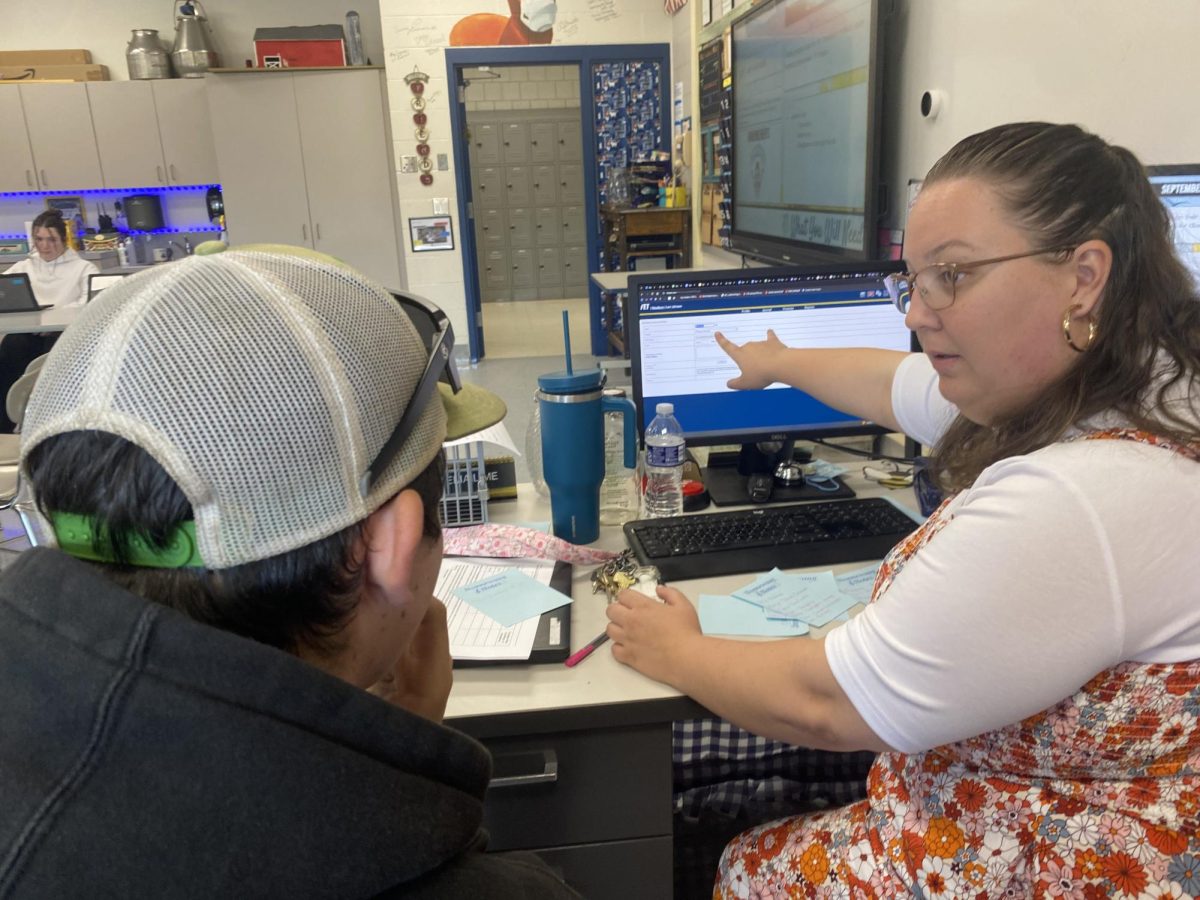 Ag instructor Kathleen Gorman, right, assists her SAE student, Levi Johnson, with filling out his AET journal. Students who previously dreaded logging their hours now have the time and support to make sure it is completed during their Tribe or Focus time. Teachers, students, and  parents will see a lot fewer incomplete grades in PowerSchool this year.