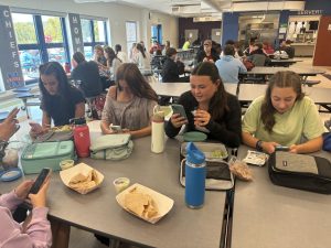 From left, Maddie Gargulio, Anna Walkup, Bryce Gilbert, Elliana Obolewicz use their phones at lunch instead of socializing.