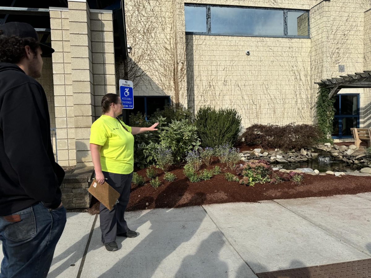 NHS' new landscaping instructor Jennifer Plasky works with her students measuring the Nonnewaug High School entrance sign for their next future project.