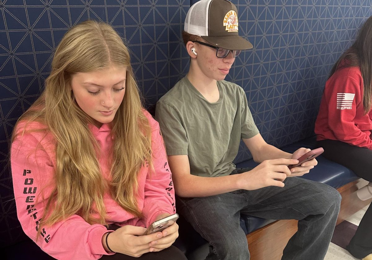 Cate Frechette, left, and Nasir Stevenson use their phones during study hall. As the year moves on, administrators and staff members are more strictly enforcing the cellphone policy.