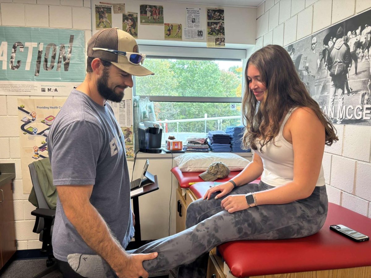 Trainer Sean checks on sophomore Sadie Turchuk's sore knee before volleyball practice. He does small examinations for many athletes at Nonnewaug.