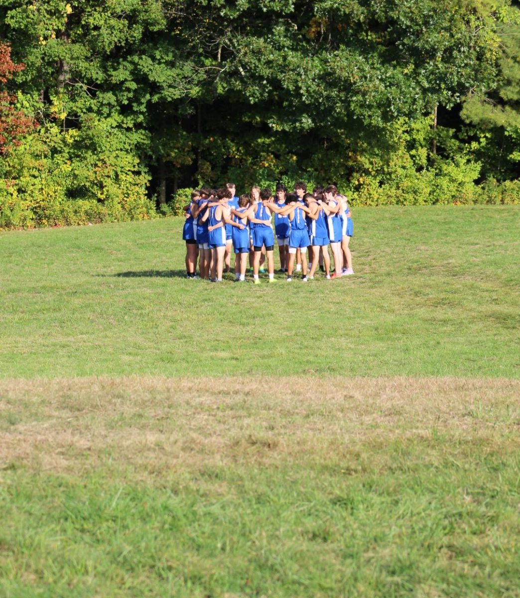 The NHS boys cross country team huddles before a meet against Lakeview on Sept. 30.