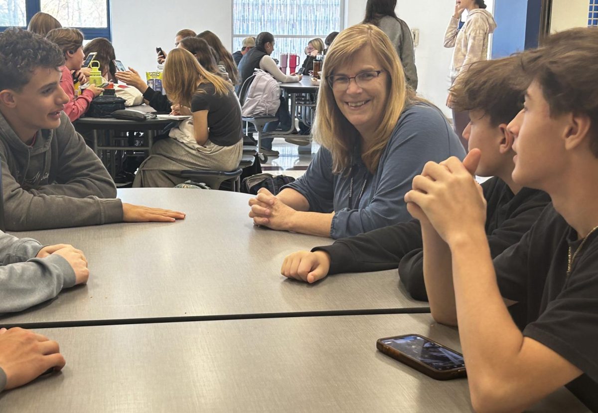 Ellie Bruce, center, talks to a group of students at lunch. She has been a fixture on NHS' campus for many years. 