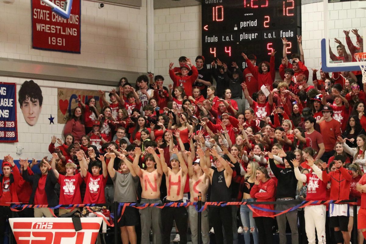 The student section raises their hands during a free throw at the Nonnewaug vs. Shepaug red-out game in February 2023. Most Nonnewaug student-athletes agree that fan sections help hype up players. (Courtesy of Noreen Chung)