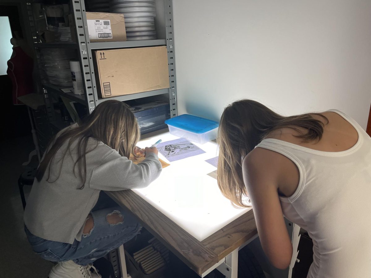 Morgan Willis, left, and Claire Rogers work on a pencil drawing at the light table.