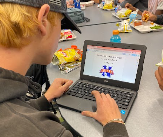 Noah Zupan, a Nonnewaug junior, looks at the 2024-25 student handbook reviewing the new policies being enforced for underclassmen.