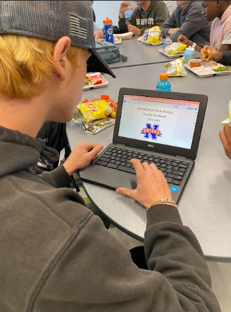 Noah Zupan, a Nonnewaug junior, looks at the 2024-25 student handbook reviewing the new policies being enforced for underclassmen.