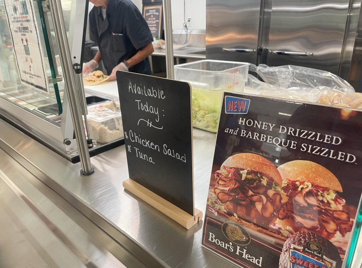 A Nonnewaug cafeteria worker prepares a wrap using Boar’s Head products. Boar’s Head recalled more than 7 million pounds of products this summer because of a Listeria outbreak.