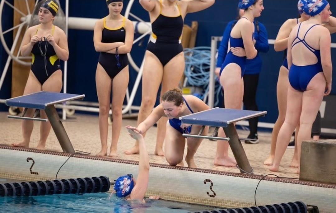 Deme Jones gives a high five to teammate Kristi Sundstrom during a swim meet last season. The swim team hopes to raise awareness of meets to earn the attention of their classmates as the season draws nearer. (Courtesy of NHS Swim & Dive/Instagram)