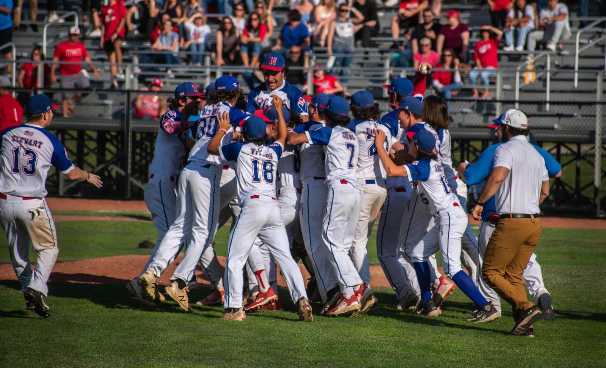 Nonnewaug athletic trainer Sean McGee, right, rushes Palmer Field after the Chiefs won the 2023 Class M state baseball championship. (Courtesy of the CIAC)