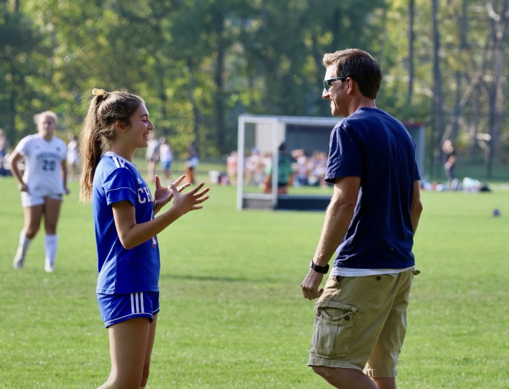 Sophomore Addi Bushka talks with varsity girls soccer coach Adam Brutting on the sideline before the Shepaug soccer game on Oct. 19. (Courtesy of Jennifer Salisbury)