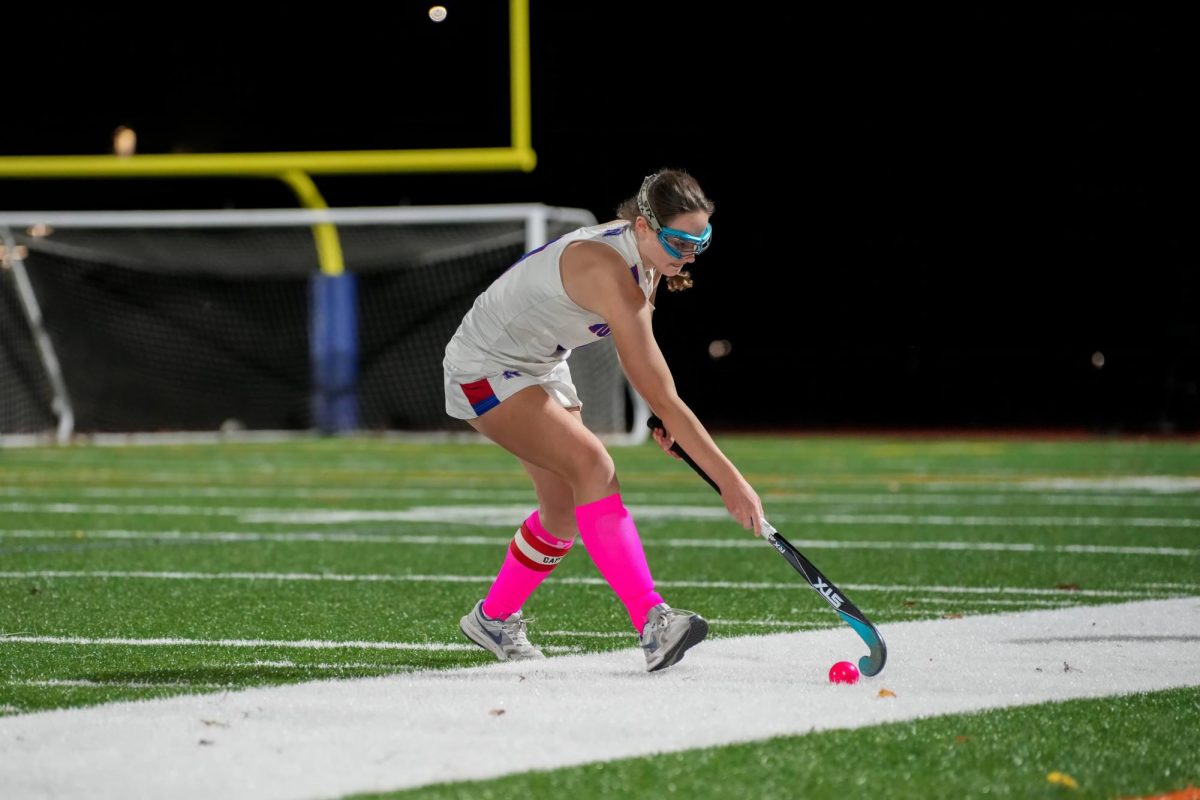 Senior field hockey player Kelly Farrell handles the ball up the sideline. She wears face goggles to protect her face, but still obtained a face injury this season. This is one of the reasons why other players on the Nonnewaug field hockey team opt not to wear them. (Courtesy of Jason Scozzafava)